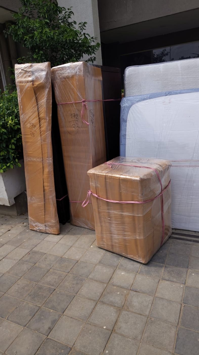 Wrapped mattress and cartons staged at the doorstep before loading
