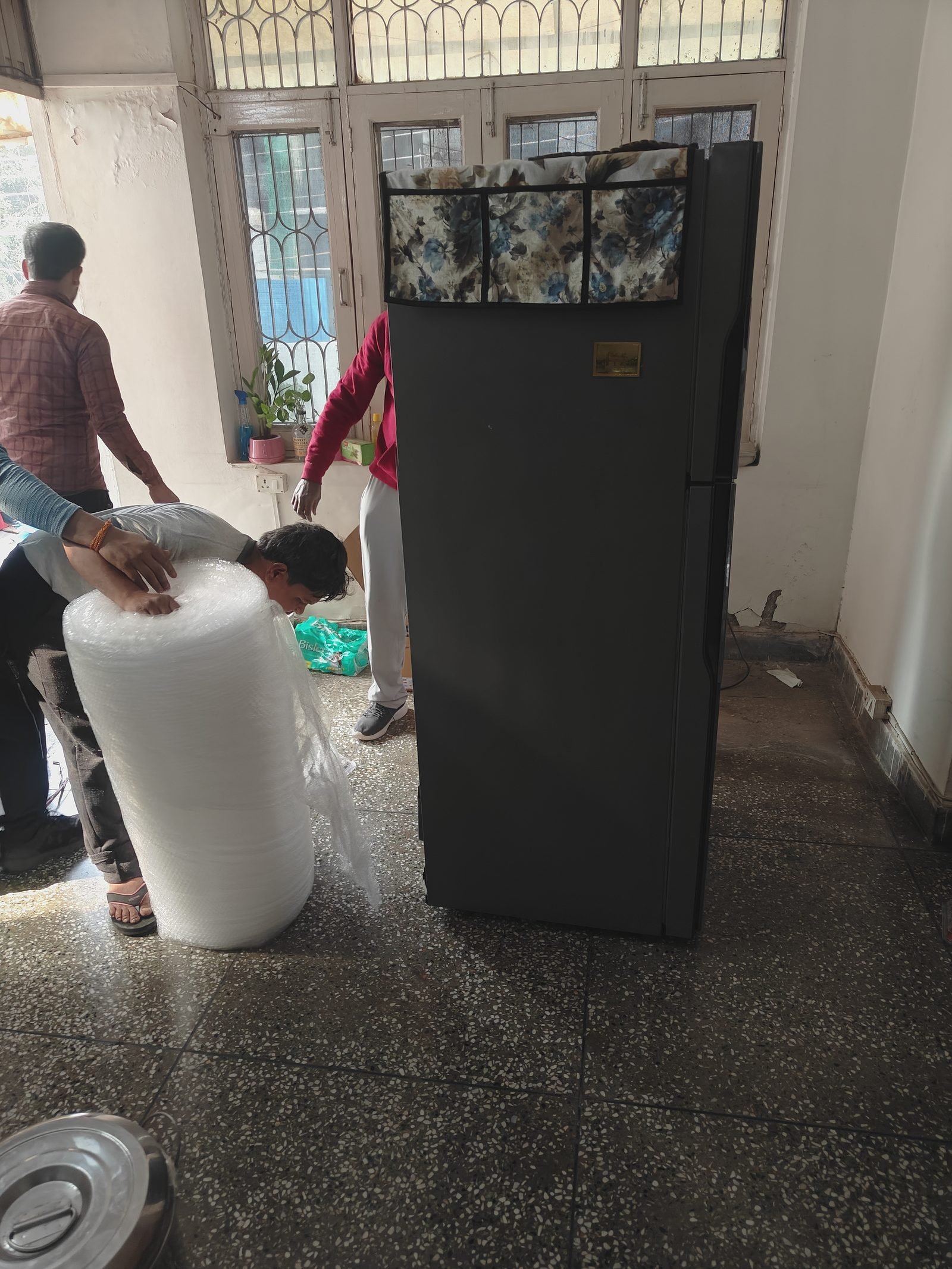 Bubble wrap ready beside a fridge being packed for shifting
