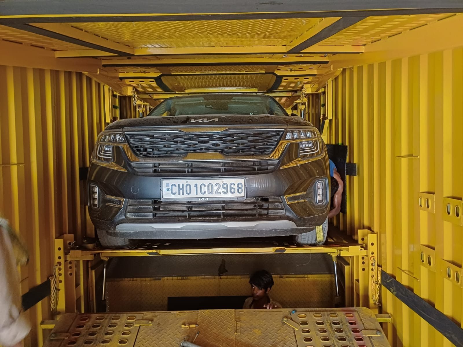 Car being loaded onto a covered transport carrier