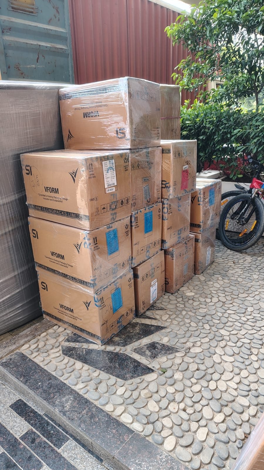 Packed cartons staged for loading outside a Gurgaon society